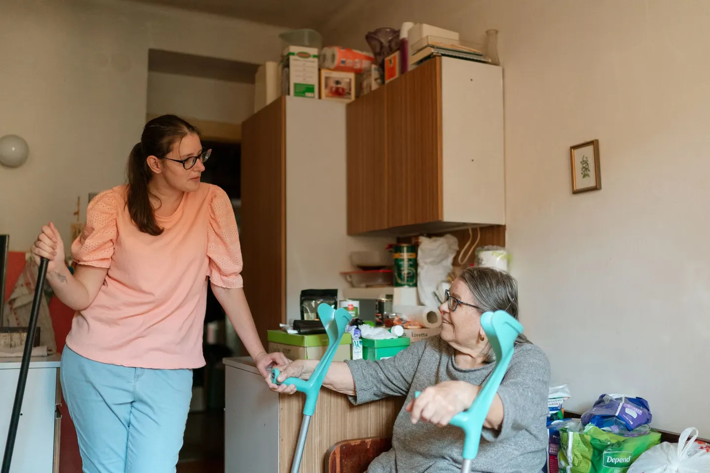 Pflegerin und ältere Frau unterhalten sich in der Küche