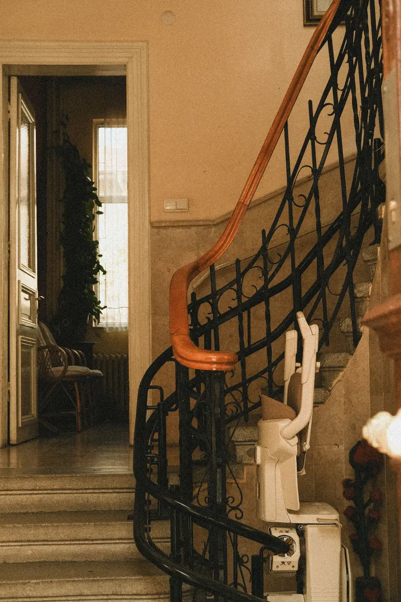 Sitzlift an einer Schiene entlang einer geschwungenen Treppe